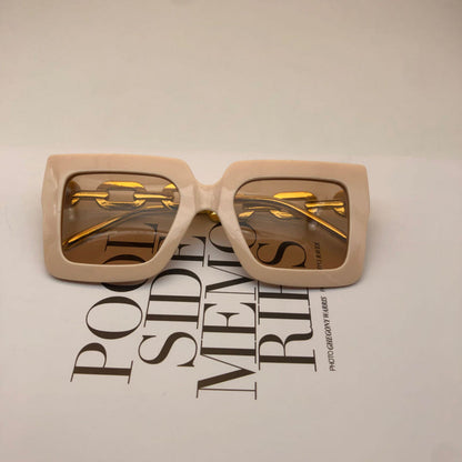 Square beige sunglasses with gold chain detail and amber-tinted lenses, front view