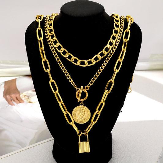 Gold chain necklace with a lock pendant on a black mannequin bust.