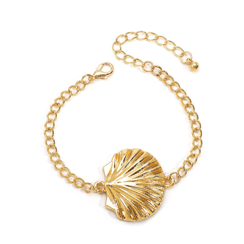 Gold bracelet with a shell charm on a white background