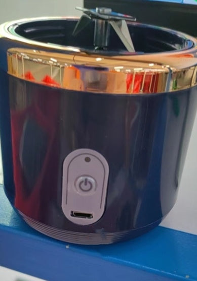 Blue and gold appliance with power button on a blue surface