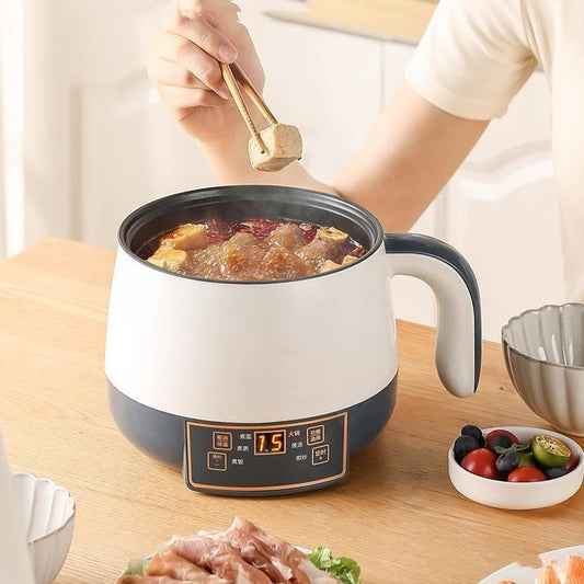 Person using a small electric pot on a table with ingredients around