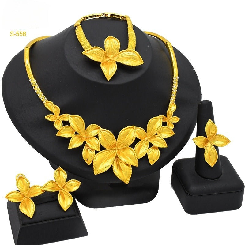 Gold necklace and earrings set on a black stand