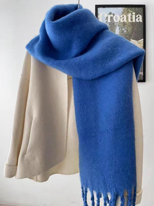 Blue scarf draped over a beige coat with a blurred background