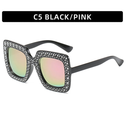 Black and pink sunglasses with gemstone accents on a white background