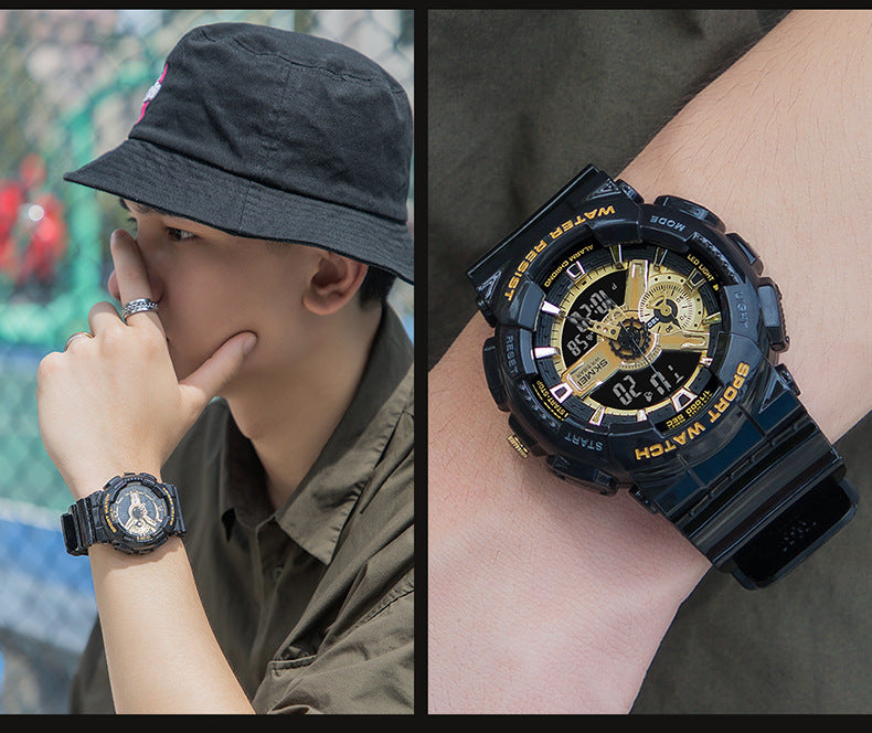 Person wearing a black and gold watch with a blurred background