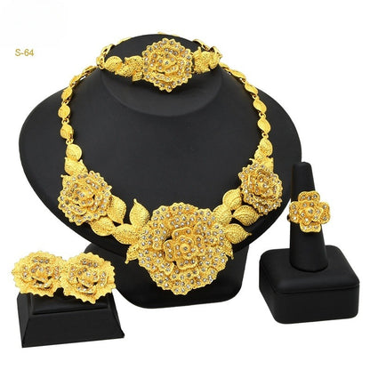 Gold floral jewelry set on a black stand with 'S-64' label.