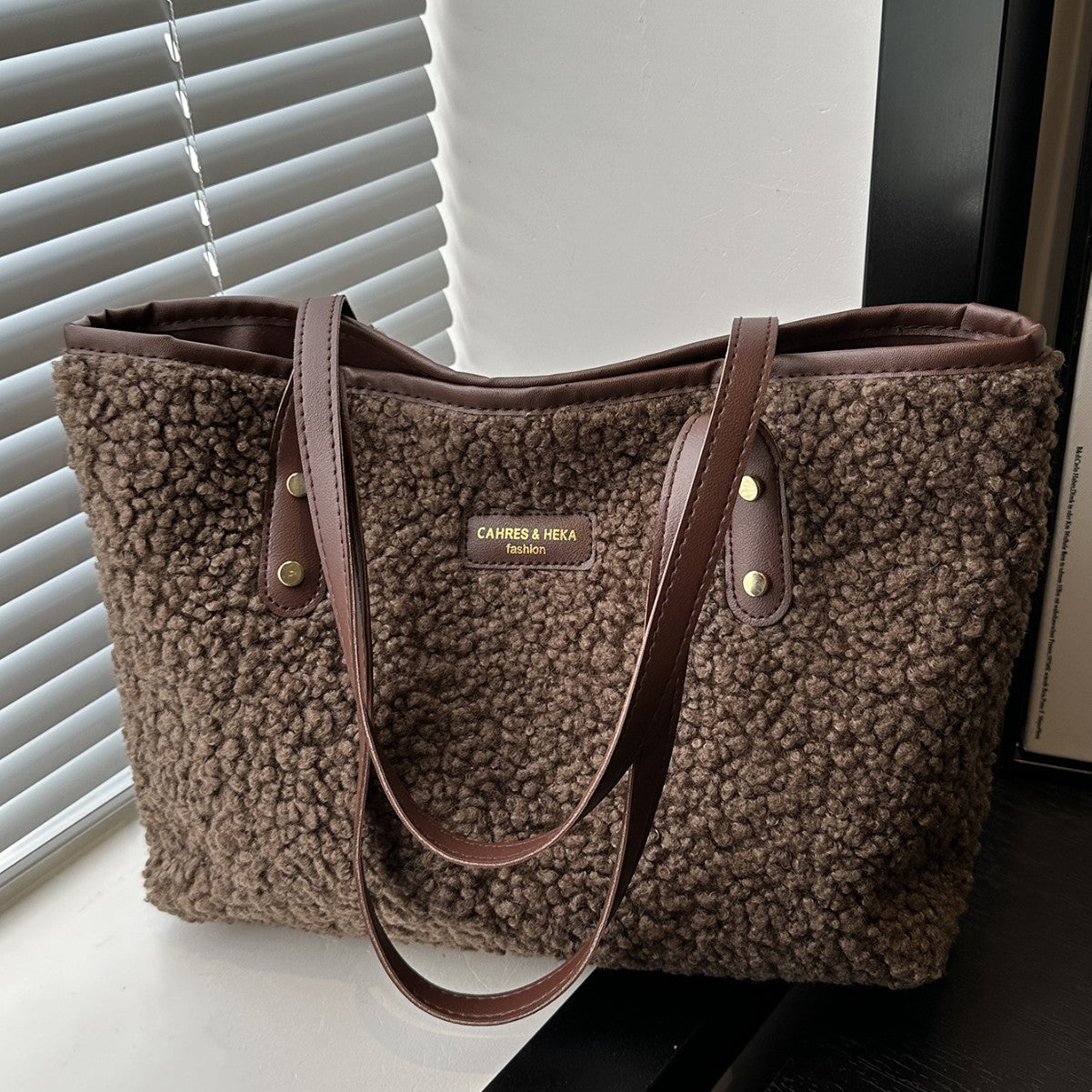 Brown furry tote shoulder bag with dual top handles and buttoned straps