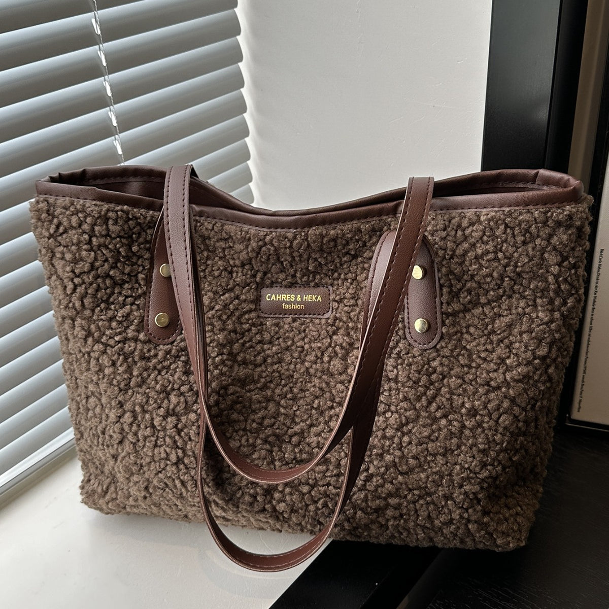 Brown furry tote shoulder bag with dual top handles and buttoned straps