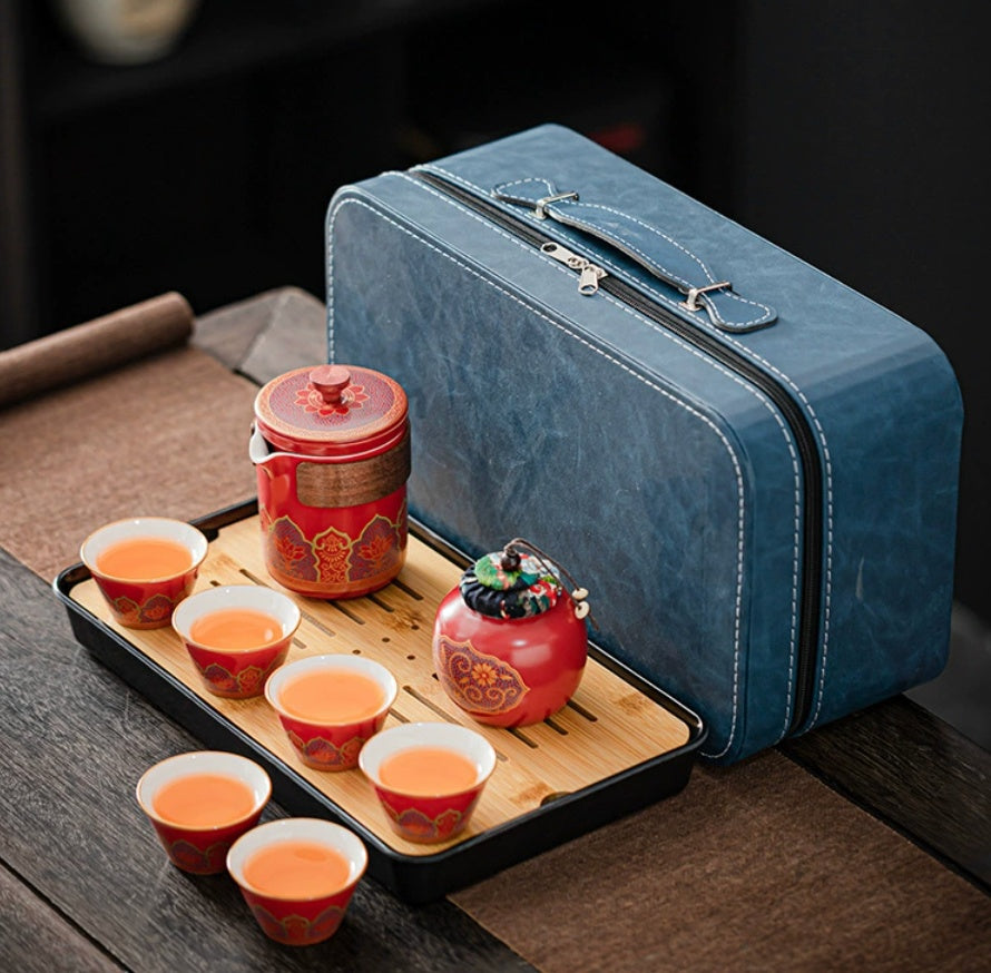Blue travel case with red tea set on a wooden tray