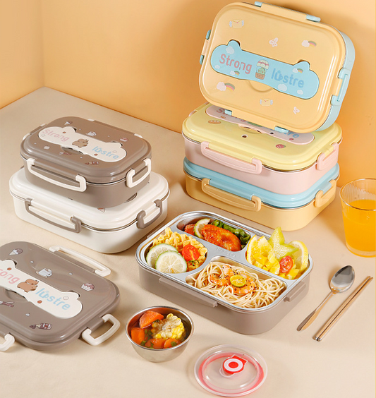 Set of colorful lunch boxes with stainless steel compartments, some filled with food, on a table with spoon, chopsticks, and drink