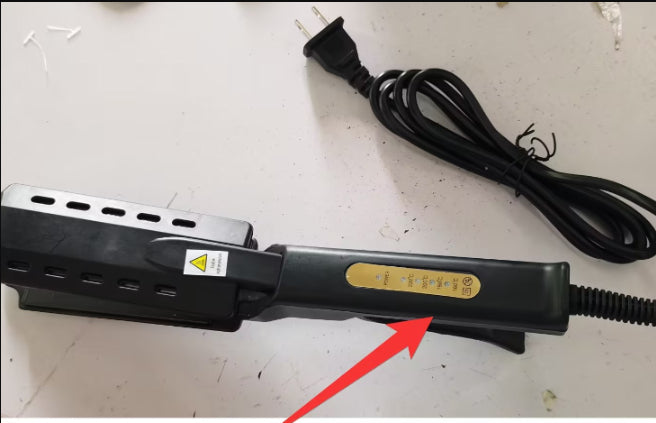 Black electronic device with a power cord on a white surface