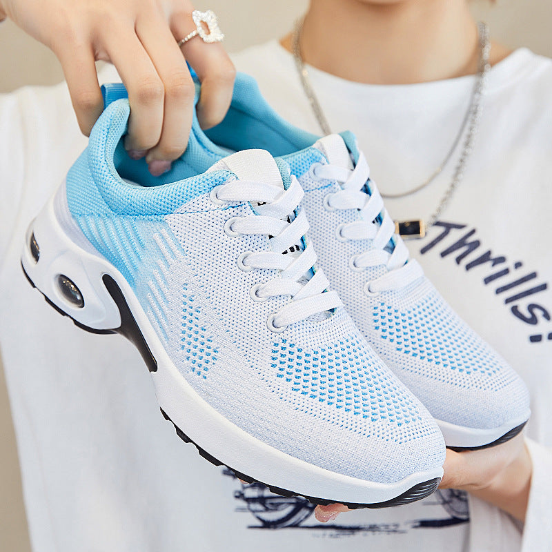 Blue and white athletic shoes being held by a person