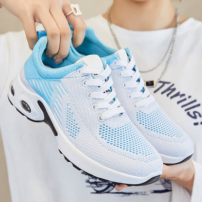 Blue and white athletic shoes being held by a person