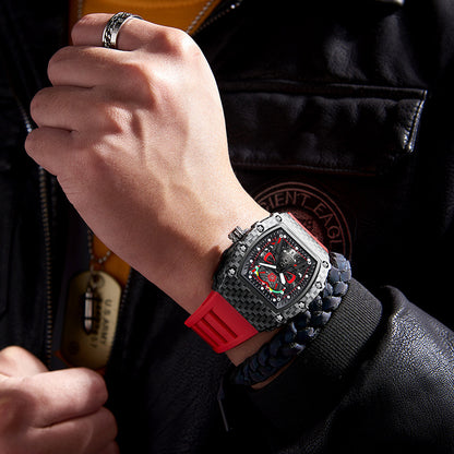 Close-up of a person wearing a watch with a red strap on a dark background