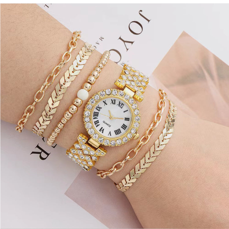 Gold bracelet and watch set on a wrist with a magazine background