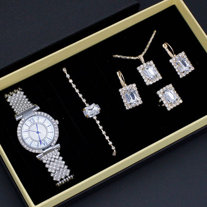 Jewelry set including a watch and earrings on a black background