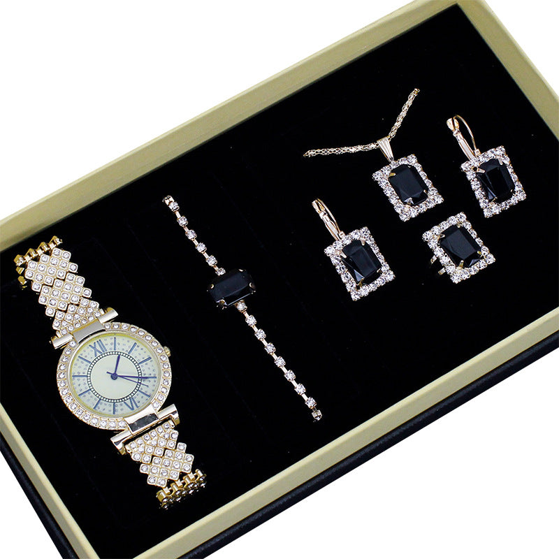 Jewelry set with a watch and necklaces on a black background