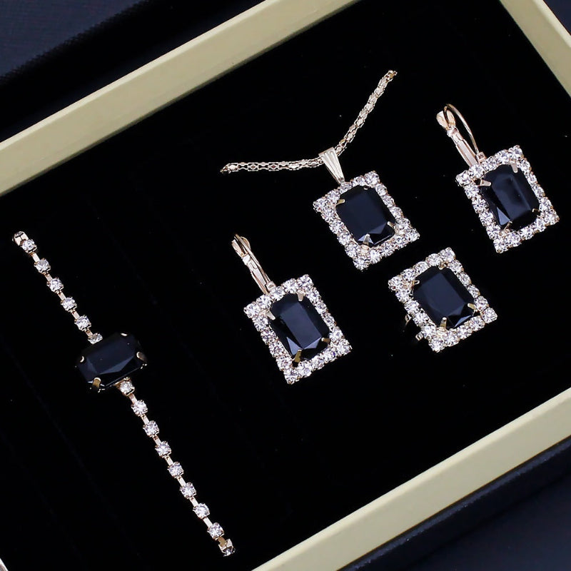 Jewelry set with blue gemstones and diamond accents on a black background