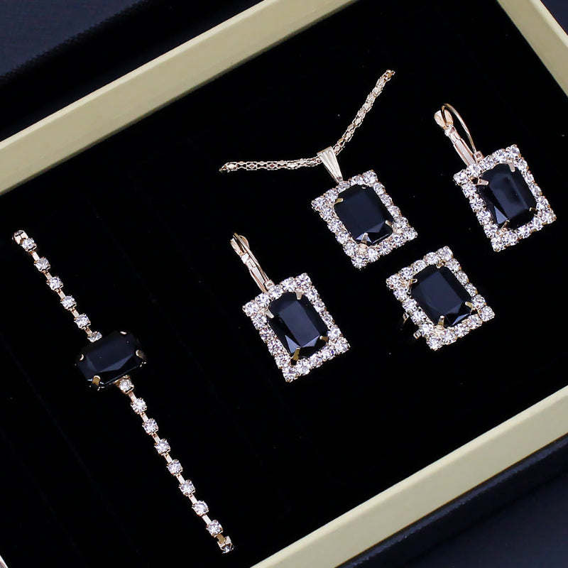 Jewelry set with blue gemstones and diamond accents on a black background
