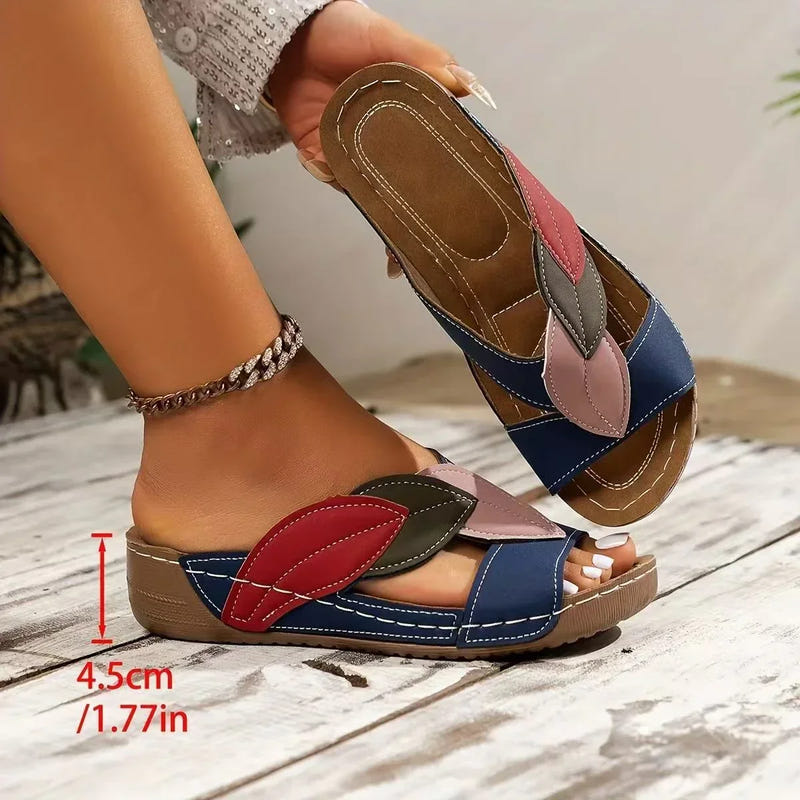 Women’s open-toe sandals with blue upper and multi-color leaf strap accents on tan sole