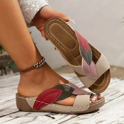 Women’s lightweight sandals with beige sole, white straps, and red/gray leaf appliques