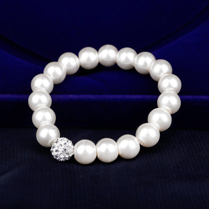 Pearl bracelet with a crystal clasp on a dark blue fabric background