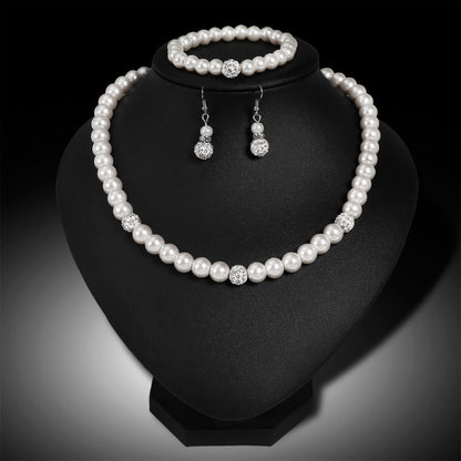 Pearl necklace, bracelet, and earrings set on a black stand