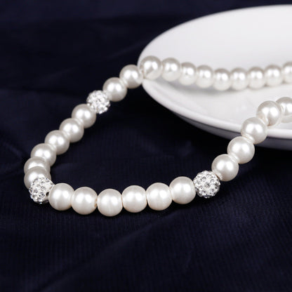 Pearl necklace with crystal beads on a dark fabric background