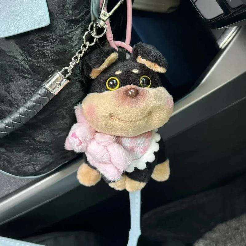 Puppy plush keychain with pink hood sweater, attached to pink strap and metal chain