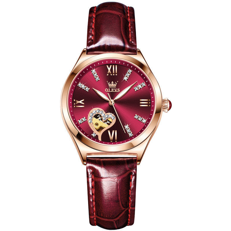 Luxury watch with red face and leather strap on a white background