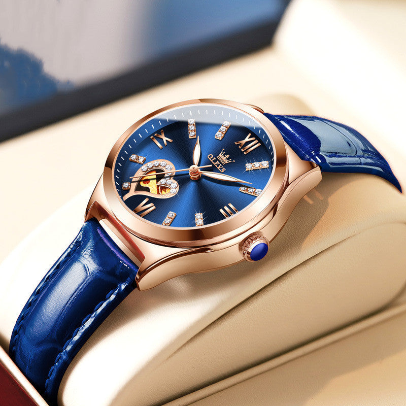 Luxury watch with blue strap and rose gold case on a beige surface