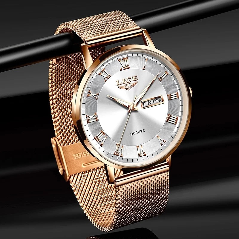 Rose gold watch with silver face on a black background