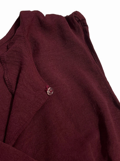 Close-up of a maroon garment with a button on a white background