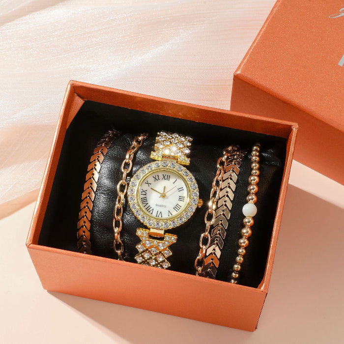 Set of jewelry including a watch and bracelets in an orange box on a beige background