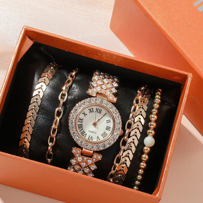 Set of jewelry including a watch and bracelets in an open box.