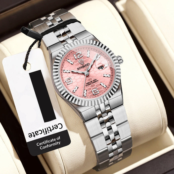 Silver watch with pink face on a white cushion, accompanied by a tag displaying a retail price.