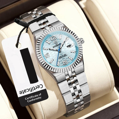 Silver women's wristwatch with a blue face on a beige cushion, accompanied by a price tag.