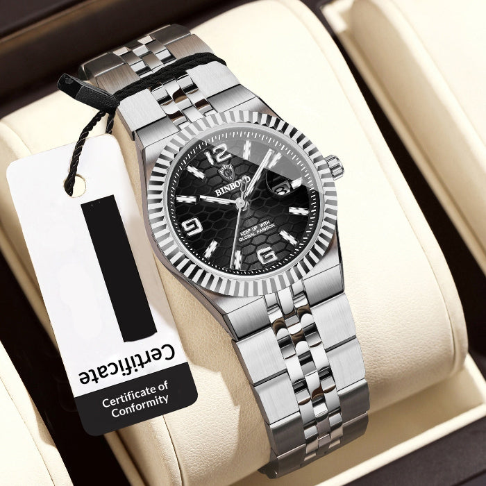 Silver women's wristwatch with black dial on a beige cushion, accompanied by a price tag.