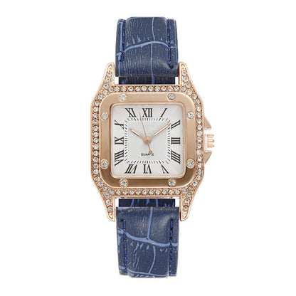Watch with blue strap and rose gold case on a white background