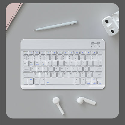 White keyboard on a gray desk with a pen, mouse, and earbuds.