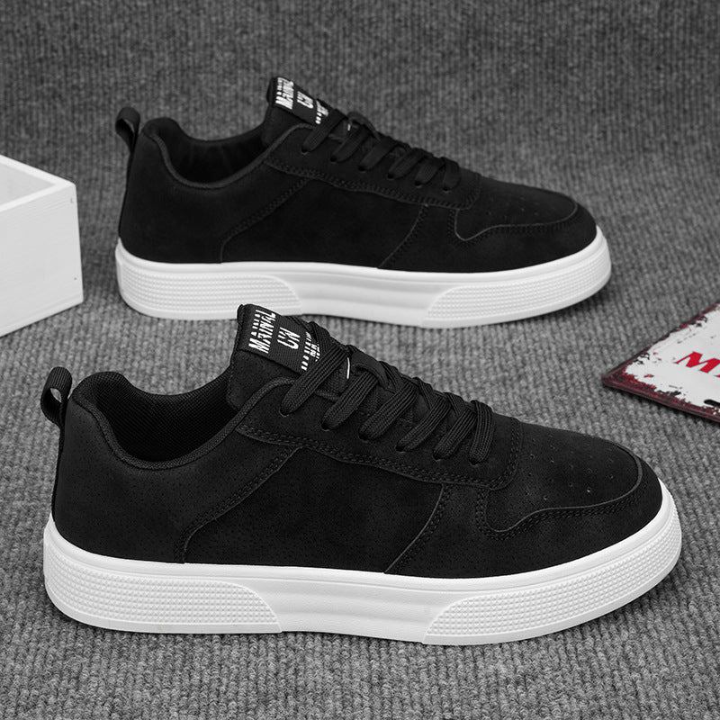 Black sneakers with white soles on a gray surface