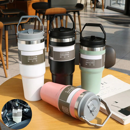 Four vacuum insulated travel mugs on a table with a blurred indoor background
