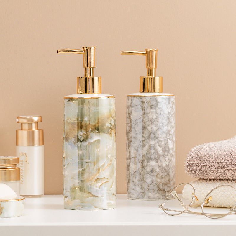 Set of skincare products with marble-textured bottles on a beige background