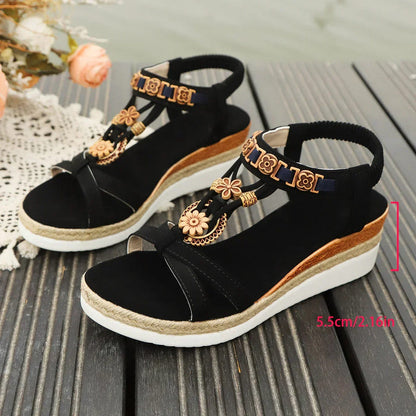 Black open-toe thick-sole sandals with gold floral decor and ankle straps, side view