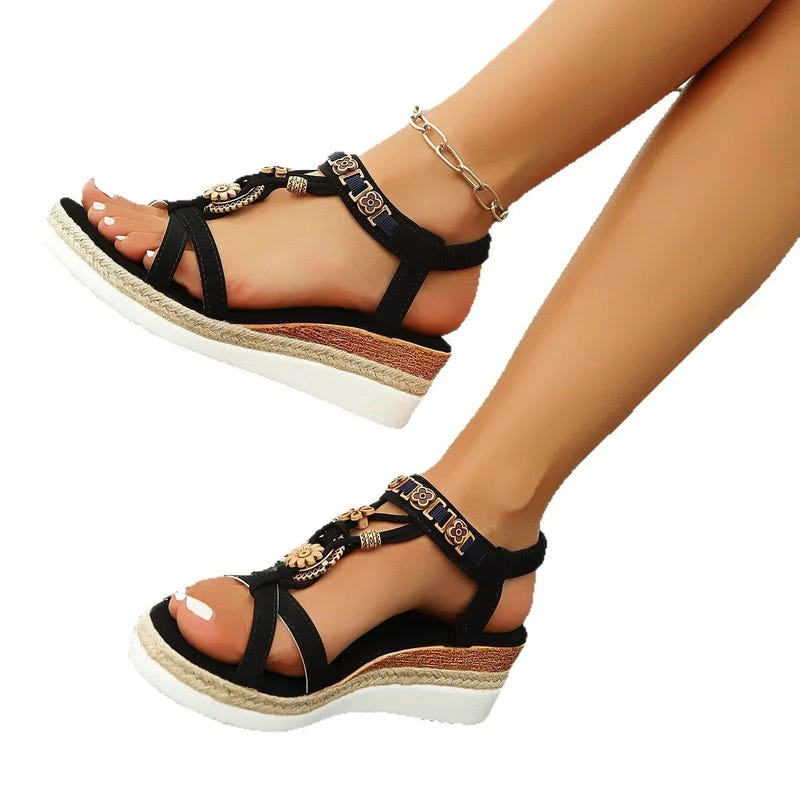Black open-toe platform sandals with thick sole, gold floral charms and ankle bracelet