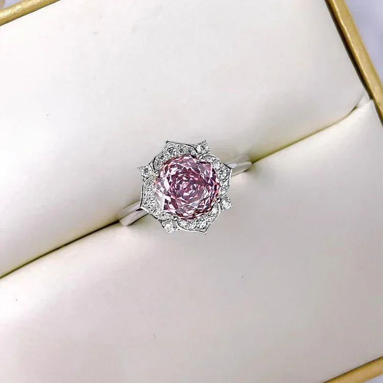 Pink gemstone flower halo ring with detailed silver prong setting on band.