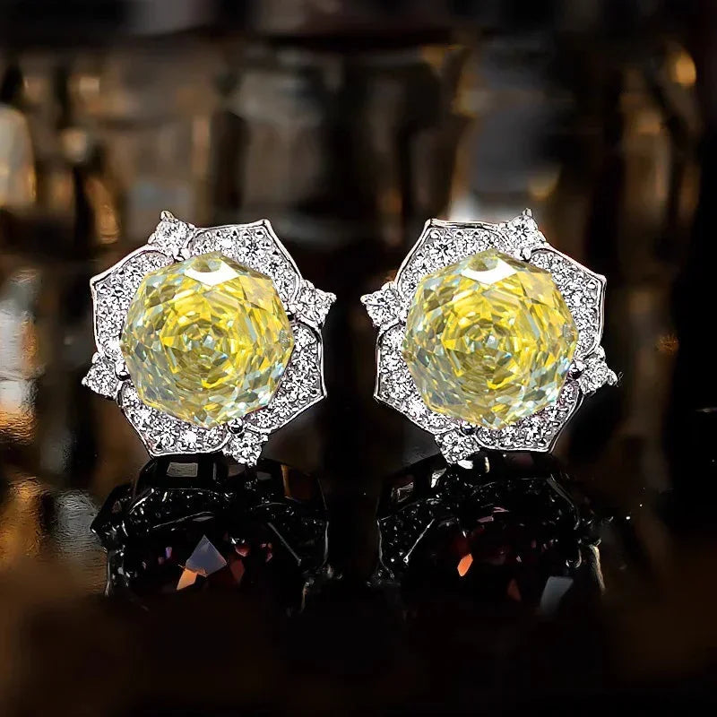 Pair of yellow gemstone flower halo stud earrings in silver-tone settings.