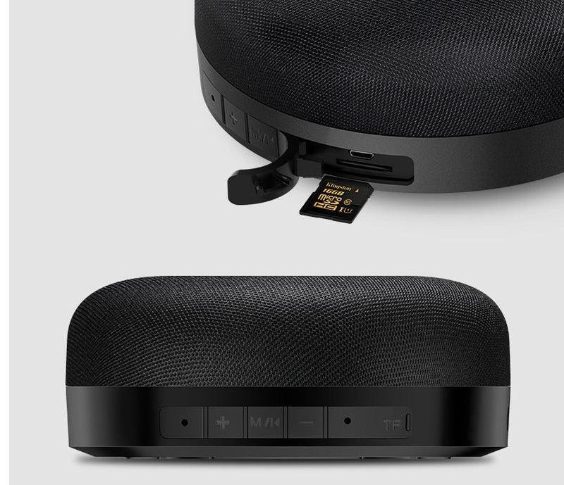 Black fabric Bluetooth speaker with control buttons and USB port on side panel