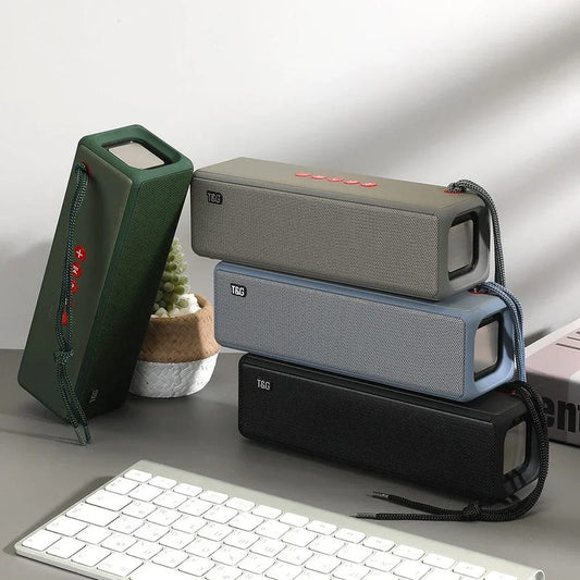 Portable square mini Bluetooth speaker with fabric grille, handle, and top controls