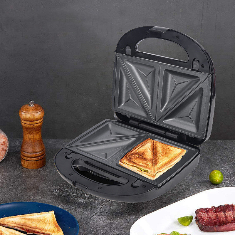 Black sandwich toaster with a toasted sandwich inside, on a dark surface with food items around.
